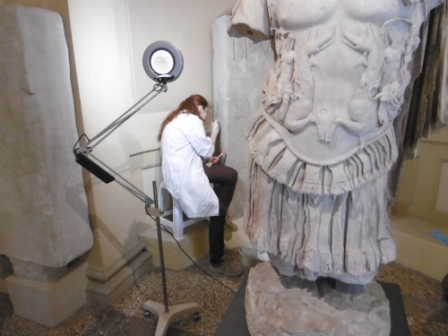 Una studentessa dell'Accademia di Belle Arti al lavoro su un cippo funerario